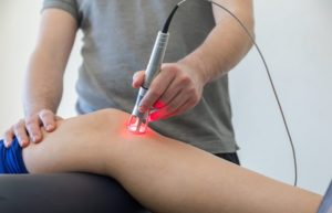 Laser Therapy On A Knee Used To Treat Pain. Selective Focus